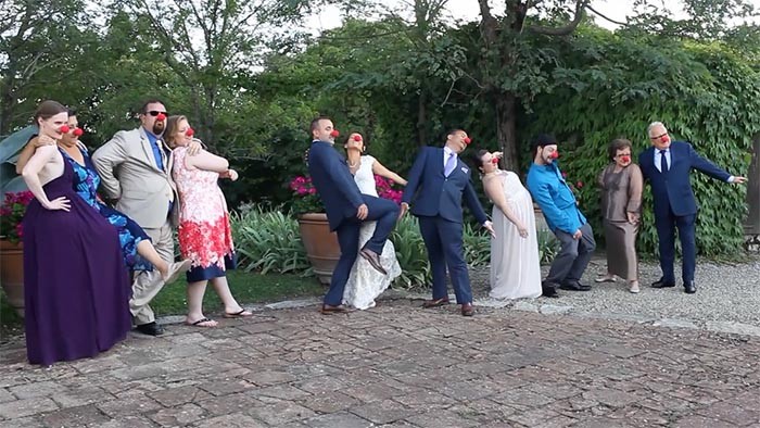 Tuscany wedding videographer: The bride and groom doing a funny photo with their guests