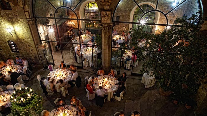 The dinner in the Castello di Vincigliata inner courtyard. Wedding videographer Florence.